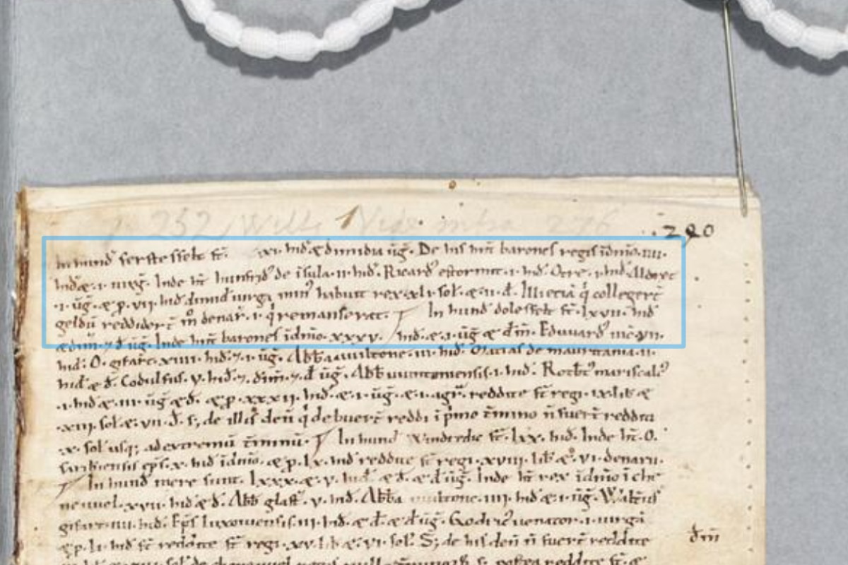 A close-up of an aged manuscript with handwritten Latin text, some underlined in blue, showing historical record-keeping details.